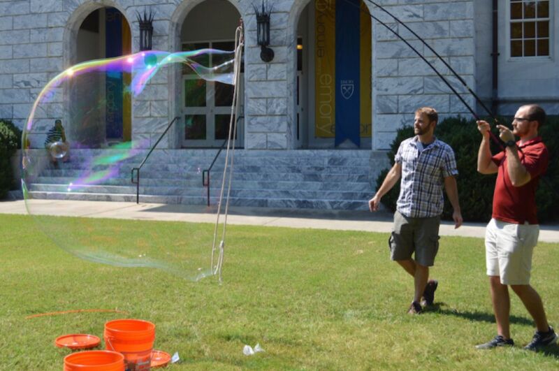 Physicist Justin Burton (left) and graduate student Stephen Frazier experiment with giant soap bubbles on Emory University's Quad.